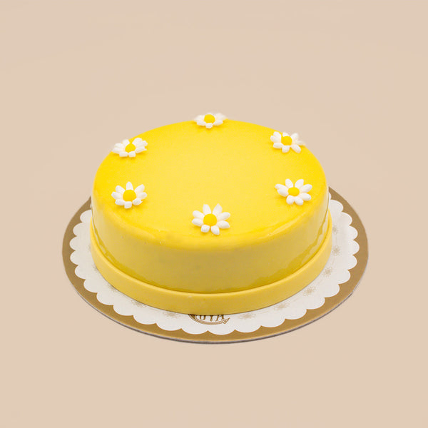 Torta mousse al mango Pasticceria Cova con glassa gialla e decorazioni floreali
